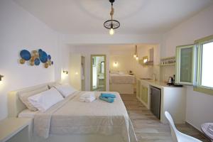 a bedroom with a large bed and a kitchen at Diasino Apartments and Car Rental in Katapola