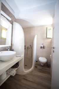 a bathroom with a sink and a shower and a toilet at Diasino Apartments and Car Rental in Katapola