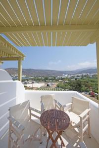 a table and chairs on a balcony with a view at Diasino Apartments and Car Rental in Katapola