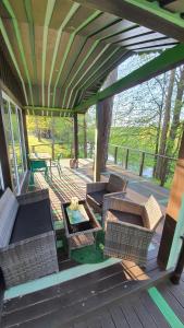 a porch with wicker chairs and a table on a deck at VIP Green House of Hope for 2 in Leliūnai