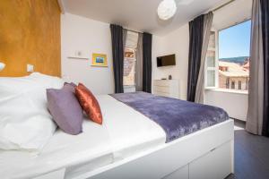 a bedroom with a large white bed with a window at Tony's Place in Dubrovnik