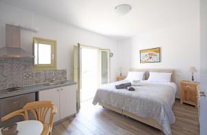 a bedroom with a bed and a table and a kitchen at Diasino Apartments and Car Rental in Katapola