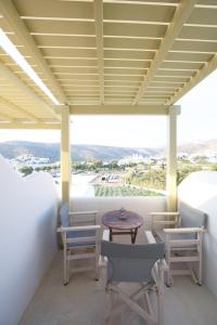 a balcony with a table and chairs and a view at Diasino Apartments and Car Rental in Katapola