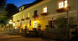 ein Gebäude mit Flaggen und Blumen davor in der Unterkunft Gasthof-Hotel zur Linde in Yspertal