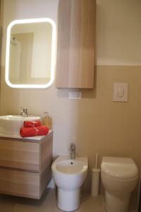 ein Badezimmer mit einem Waschbecken, einem WC und einem Spiegel in der Unterkunft Dimora Agata 21 in Ostuni