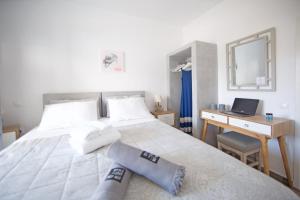 a bedroom with a bed and a desk with a laptop at Diasino Apartments and Car Rental in Katapola