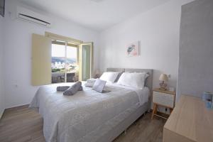 a bedroom with a large bed with a large window at Diasino Apartments and Car Rental in Katapola