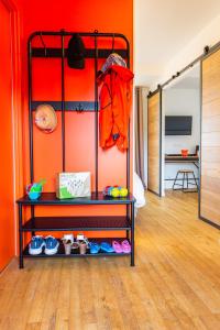 a room with a red wall and a shelf with shoes at LA PETITE PRESQU'ILE in Locoal-Mendon
