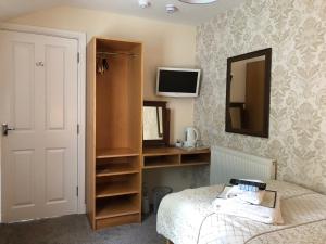 a bedroom with a bed and a mirror and a tv at 202 Guesthouse in Lincoln