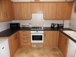 a kitchen with wooden cabinets and a stove top oven at Baird House in Thornaby on Tees