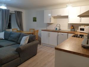 a kitchen and living room with a couch and a table at The Old School in Salen
