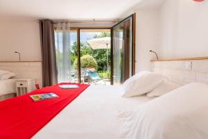 a bedroom with a large white bed with a red blanket at LA PETITE PRESQU'ILE in Locoal-Mendon