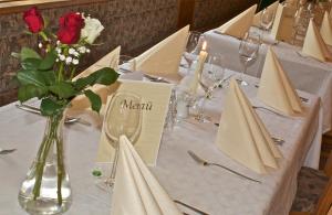 einen Tisch mit einer Vase aus Blumen und Servietten in der Unterkunft Gasthof-Hotel zur Linde in Yspertal
