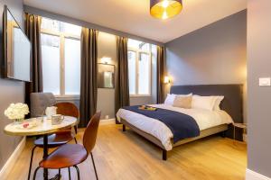 a bedroom with a bed and a table and chairs at Les appartements chics du Vieux-Port in Marseille