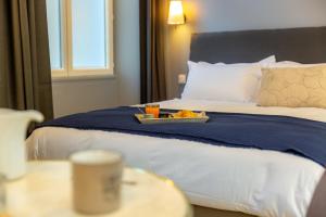a tray of food on a bed in a hotel room at Les appartements chics du Vieux-Port in Marseille