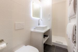 a bathroom with a white toilet and a sink at Les appartements chics du Vieux-Port in Marseille