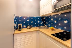 a kitchen with white cabinets and stars on the wall at Les appartements chics du Vieux-Port in Marseille
