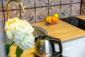a tea kettle and flowers on a kitchen counter at Les appartements chics du Vieux-Port in Marseille