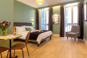 a bedroom with a bed and a table and a chair at Les appartements chics du Vieux-Port in Marseille
