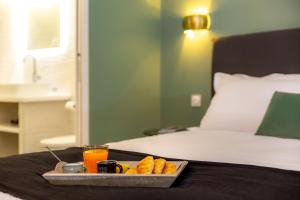 a tray with food and a drink on a bed at Les appartements chics du Vieux-Port in Marseille