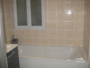 a bathroom with a bath tub and a sink at La Grande Marée in Dieppe