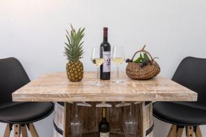a table with two glasses of wine and a pineapple at MALOA One bedroom apartment in Smokvica +10 photos