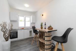 a kitchen with white cabinets and a table and chairs at MALOA One bedroom apartment in Smokvica
