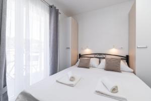 - une chambre avec un lit blanc et 2 serviettes dans l'établissement MALOA One bedroom apartment, à Smokvica