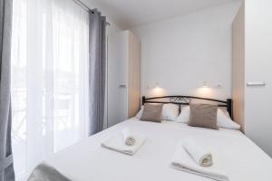 a bedroom with a white bed with two towels on it at MALOA One bedroom apartment in Smokvica