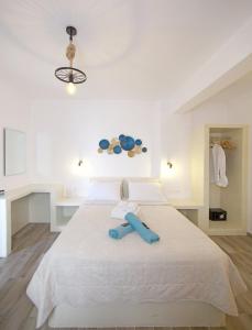 a bedroom with a large white bed with a blue object on it at Diasino Apartments and Car Rental in Katapola