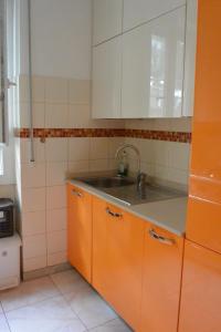 - une cuisine avec des armoires orange et un évier dans l'établissement Mare Foce e Centro, à Sanremo