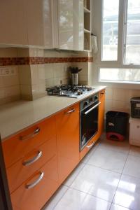 - une cuisine avec des armoires orange et une cuisinière dans l'établissement Mare Foce e Centro, à Sanremo