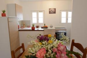 een keuken met een tafel met bloemen erop bij Le Cerf-Volant in Dieppe