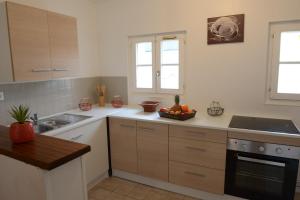 a kitchen with wooden cabinets and a bowl of fruit on the counter at Le Cerf-Volant in Dieppe