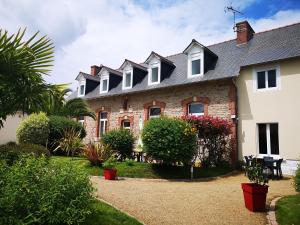 Una casa con una fila de ventanas. en Gîtes "Le Clos de La Baie", en Paimpol