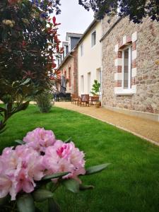 un jardín con flores rosas en la hierba en Gîtes "Le Clos de La Baie", en Paimpol