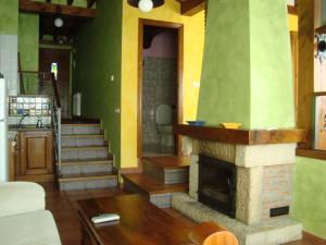 a living room with a fireplace and stairs at Apartamentos La Montaña in Frama