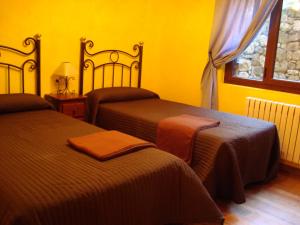 a yellow room with two beds and a window at Apartamentos La Montaña in Frama