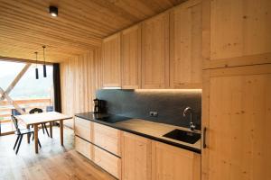 a kitchen with wooden cabinets and a sink and a table at Preindlerhof Haylofts in Valle Di Casies