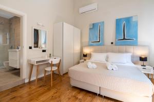 1 dormitorio con cama, escritorio y lavamanos en Letty's House - Old Town Luxury Mansion, en Rodas