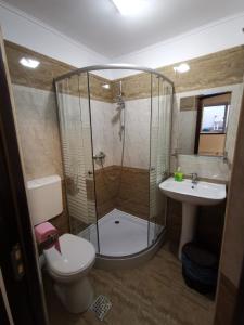 a bathroom with a shower and a toilet and a sink at Joe Hostel in Bucharest