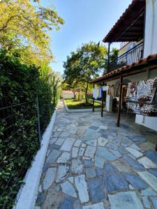 a stone walkway next to a building with a fence at Dionisos Studios and Apts Skiathos in Koukounaries