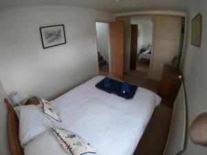 Anchor Cottage في إيست كاوز: غرفة نوم عليها سرير مع حقيبة زرقاء