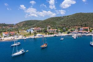 a group of boats in the water near a beach at Notia Luxury Living in Porto Koufo