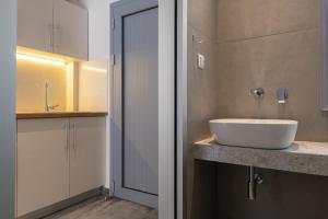 a bathroom with a white sink on a counter at Notia Luxury Living in Porto Koufo +37 photos