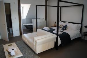 1 dormitorio con cama con dosel y sofá blanco en Montys Accommodation, en Lewes