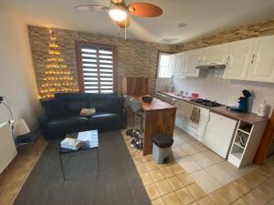 a kitchen and living room with a couch and a table at Les plantous de Severo in Cénac-et-Saint-Julien