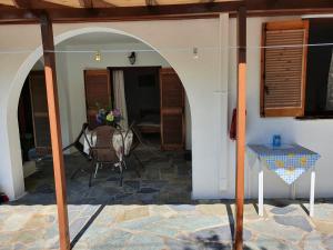 een patio in een huis met een tafel en stoelen bij Dionisos Studios and Apts Skiathos in Koukounaries
