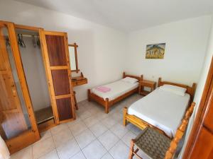 a small room with two beds and a cabinet at Dionisos Studios and Apts Skiathos in Koukounaries
