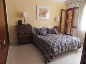 um quarto com uma cama e uma cómoda com uma mesa de cabeceira em CAN PICAFORT em Can Picafort